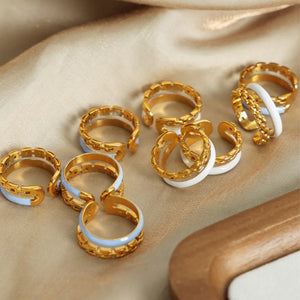 Gold chain link open rings with light blue and white enamel details.