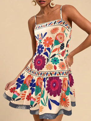 Beige mini dress with vibrant floral print, spaghetti straps, and tiered hem.