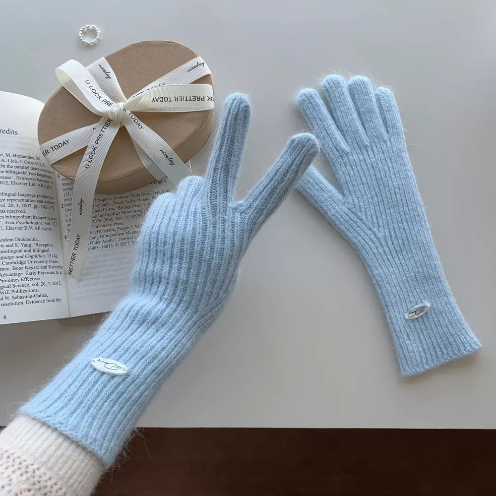Pastel blue ribbed knit touchscreen gloves with fuzzy trim and small oval logo detail.