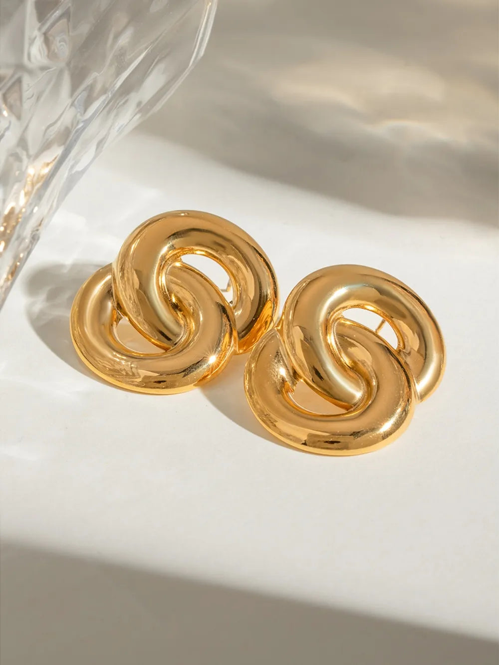 Gold interlocking statement earrings with 18K gold plating.