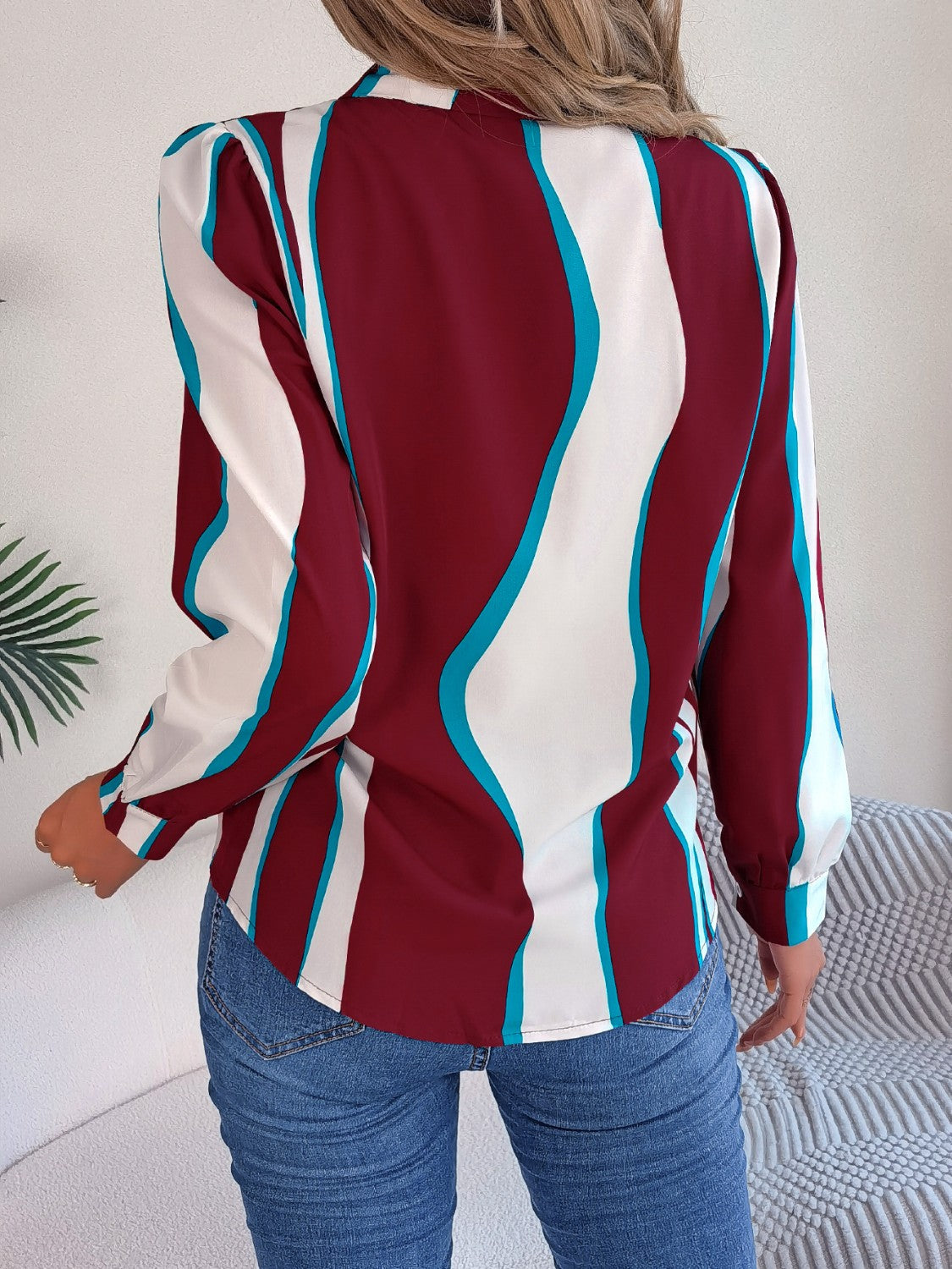 Burgundy wavy stripe collared blouse with long sleeves, styled with jeans.
