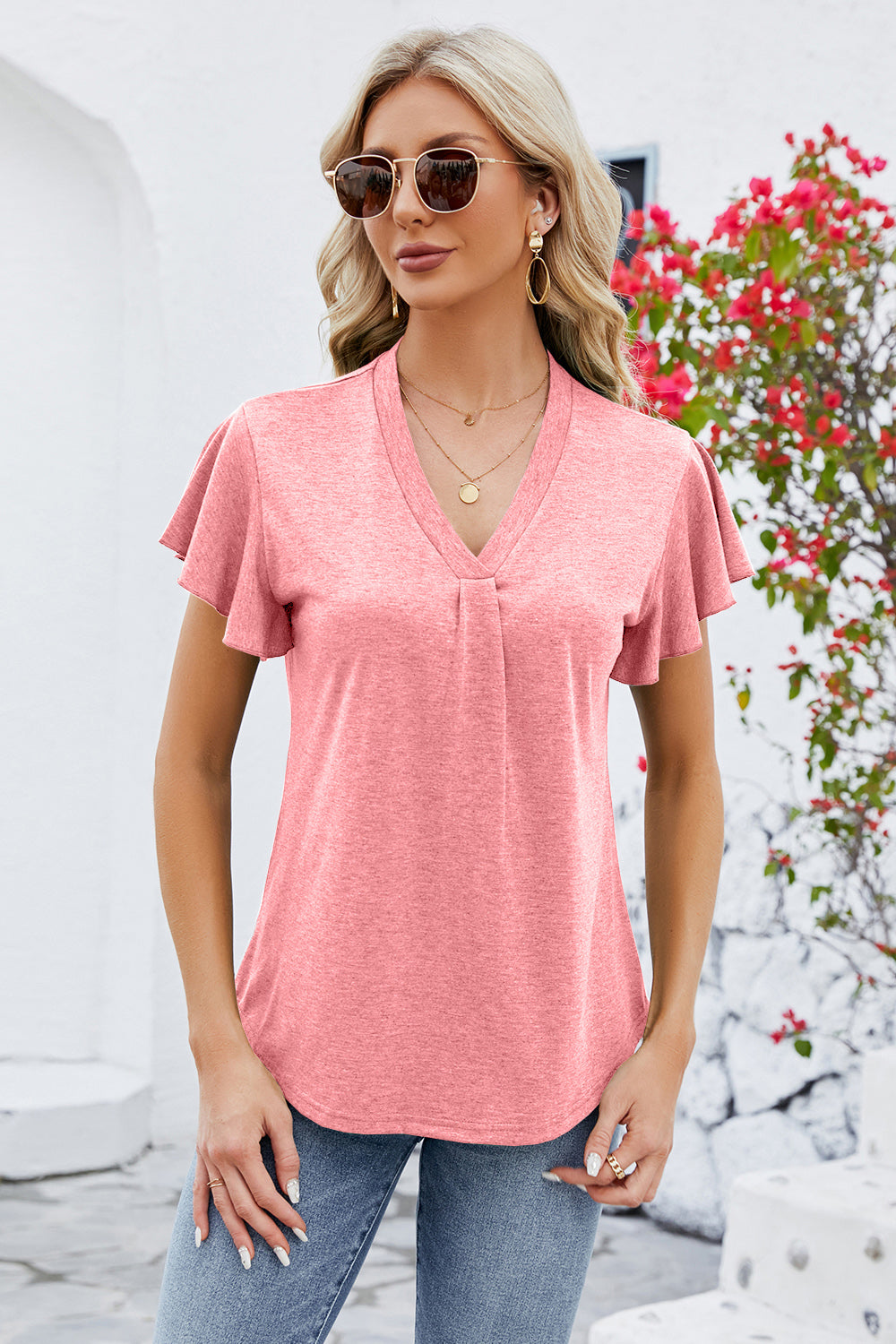 Coral V-neck top with pleated front and flutter sleeves.