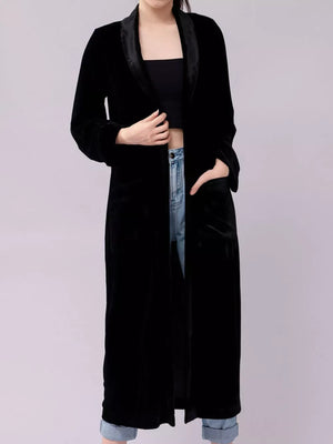 Black velvet longline trench coat with shawl collar and draped open front.