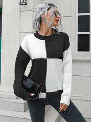 Colorblock knit sweater with black and white checkerboard pattern, crew neck, and long sleeves.
