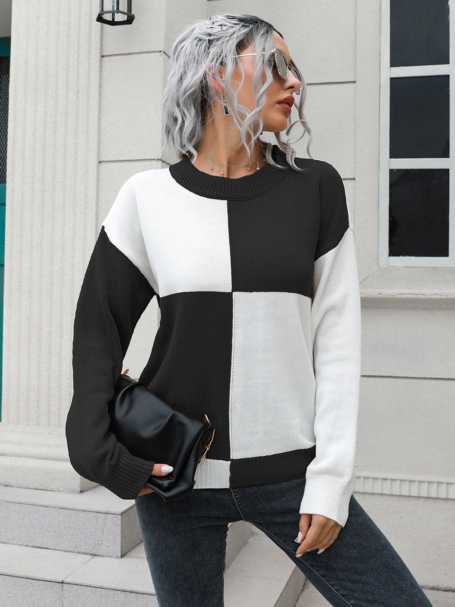 Colorblock knit sweater with black and white checkerboard pattern, crew neck, and long sleeves.