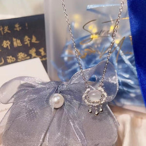 Dainty silver necklace with a chalcedony lock pendant, delicate charms, and crystal accents.