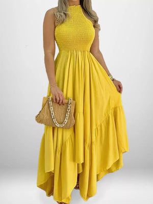 Yellow smocked halter maxi dress with ruffle hem and flowy skirt.