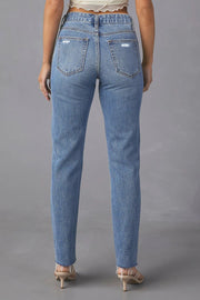 Distressed medium wash straight leg denim jeans with frayed hem.