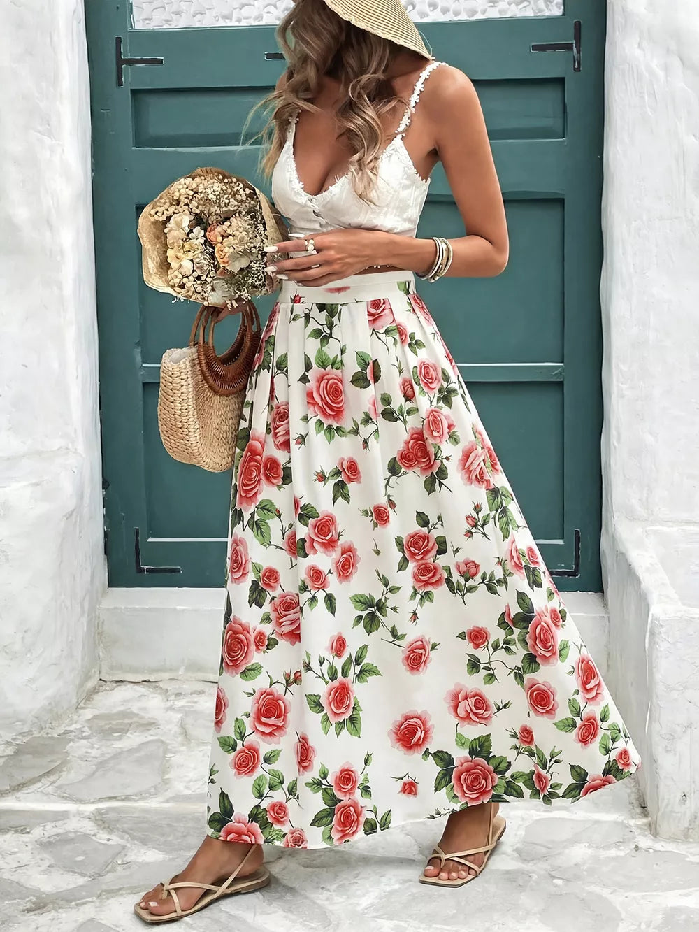 Elegant floral maxi skirt with red roses on white, featuring pleats and a flowing cut.