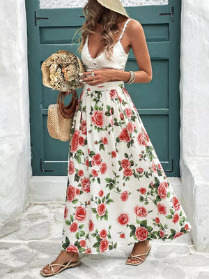 Elegant floral maxi skirt with red roses on white, featuring pleats and a flowing cut.