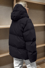 Black oversized puffer jacket with hood and horizontal quilting detail.