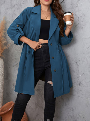 Dusty blue trench coat with gathered waistline and roll-up sleeves.