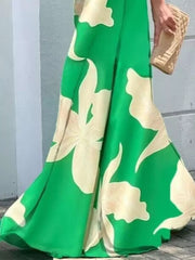 Green Flower maxi dress with large botanical print, flowing skirt, and tie-front detail.
