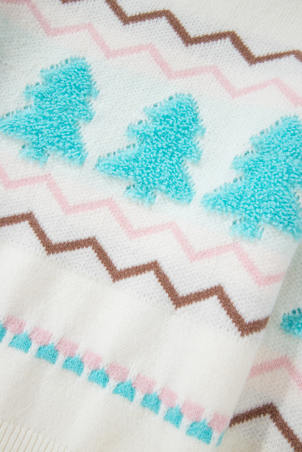 White acrylic knit sweater with textured tree motifs and chevron patterns.