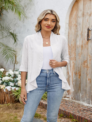 White eyelet cascade cardigan with open front and 3/4 sleeves, styled with a tank top and jeans.