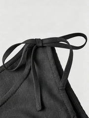 Black embellished vest with tie shoulder straps and textured fabric detail.