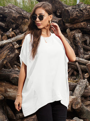 White draped asymmetrical sleeve blouse with a relaxed fit, styled with black pants.