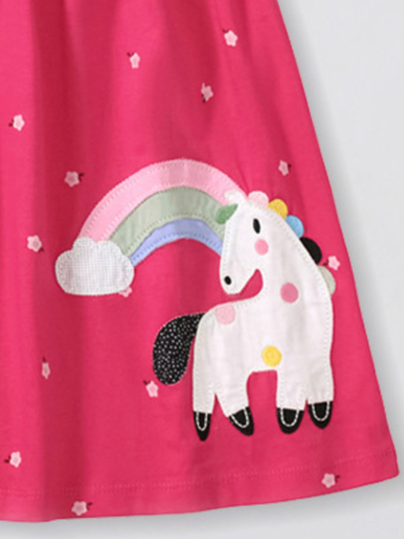 Toddler cotton dress with unicorn and rainbow applique on pink fabric.