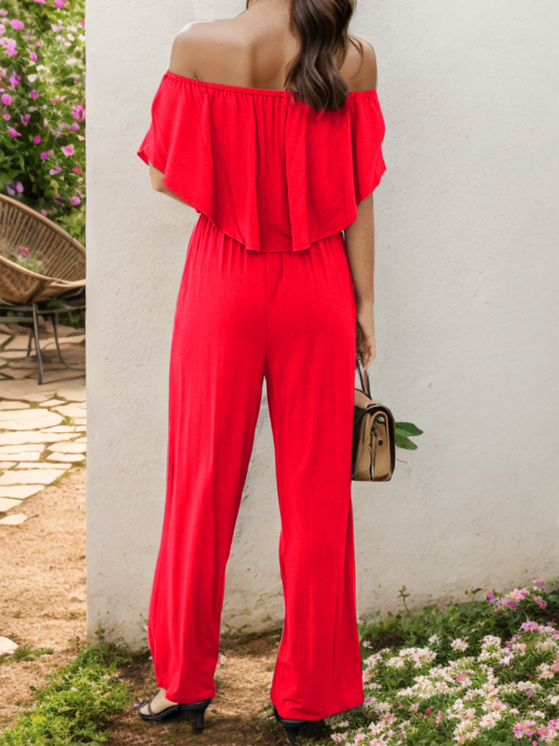 Red off-the-shoulder flounce jumpsuit with wide legs.