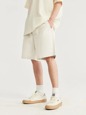 Men's ivory chino shorts with drawstring detail and knee-length cut.