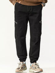 Men's black cotton cargo pants with zippered pockets and drawstring waist.