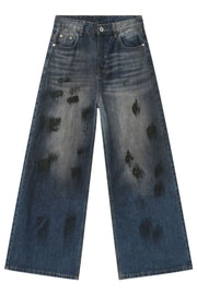 Oversized charcoal wash denim jeans with distressed black paint splatters and wide leg.