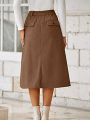 Brown corduroy midi skirt with buttoned flap pockets and elastic waistband.