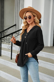 Black textured henley hooded tunic with drawstring and button detail, long sleeves.