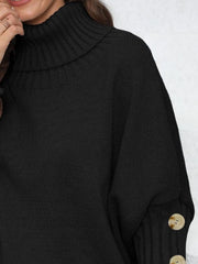 Black turtleneck sweater with button cuffs and ribbed detailing.