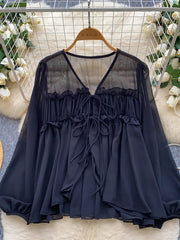 Black chiffon blouse with ruffled tie-front and sheer yoke.