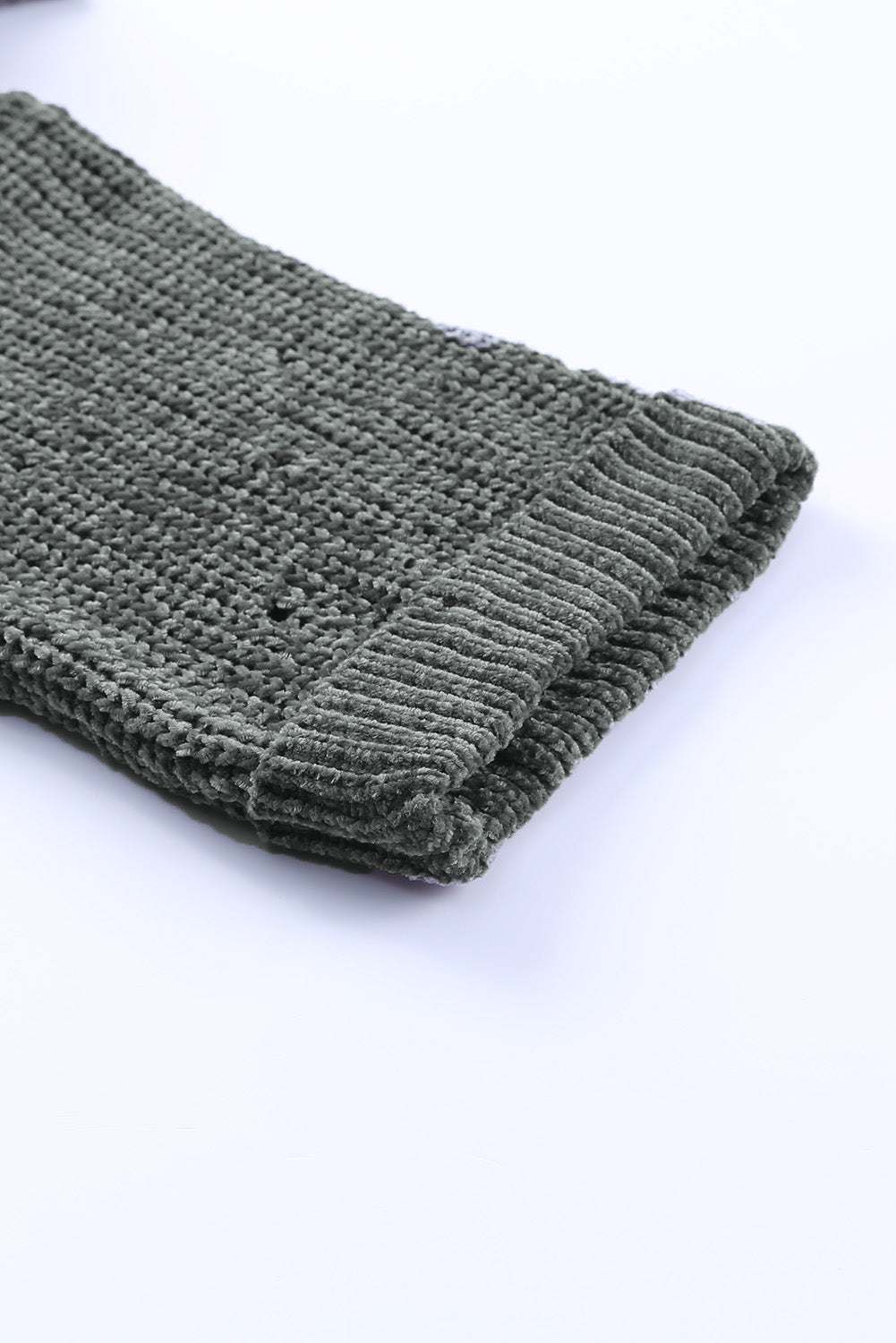 Distressed knit sweater in dark gray with a textured weave and ribbed cuff detail.