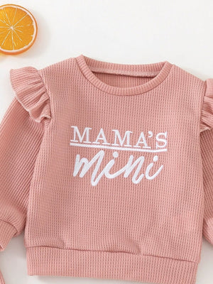 Pink waffle knit toddler top with ruffled sleeves and "Mama's Mini" embroidery