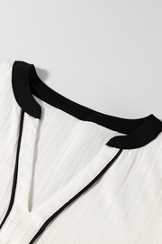 White textured V-neck blouse with black trim detail