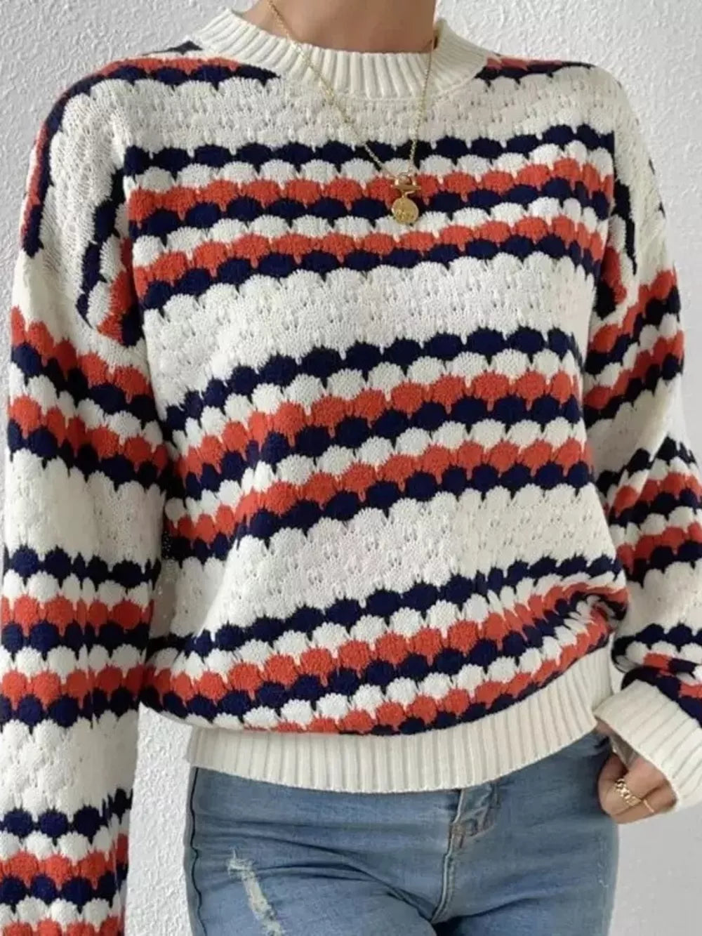 Textured striped knit sweater in white, coral, and navy with a crew neck and long sleeves.