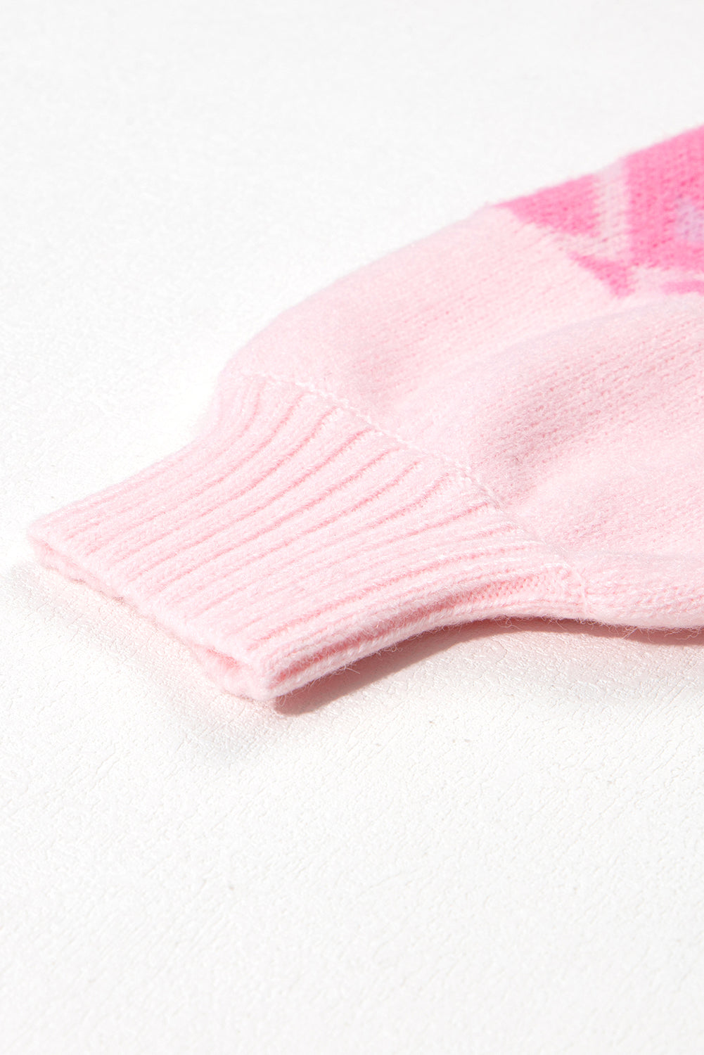 Pink acrylic knit sweater with geometric pattern and ribbed cuff detail.