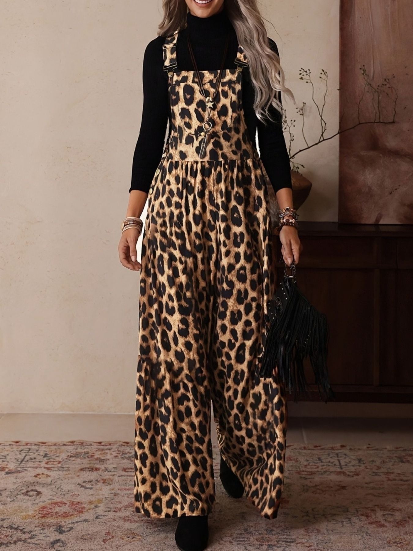 Leopard print wide leg romper with adjustable buckle straps and a black turtleneck underneath.