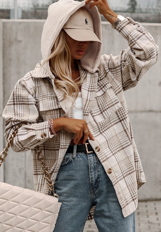 Oversized plaid shacket with attached hoodie and button front, styled with jeans and a baseball cap.