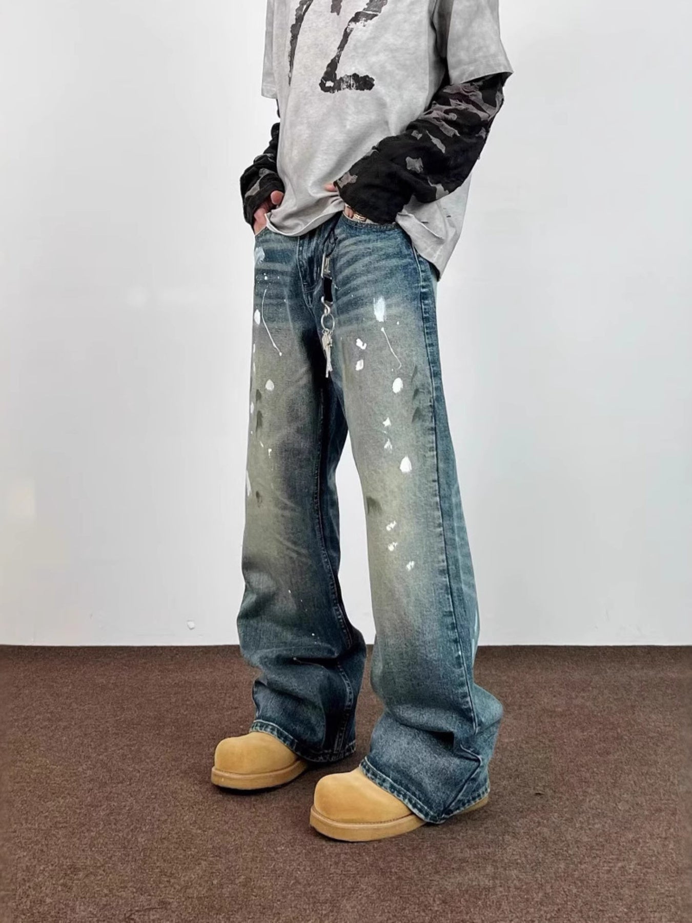 Men's blue 100% cotton wide leg jeans with paint splatters and distressed details.