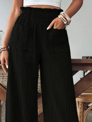 Black textured gauze palazzo trousers with elastic waist and pockets.
