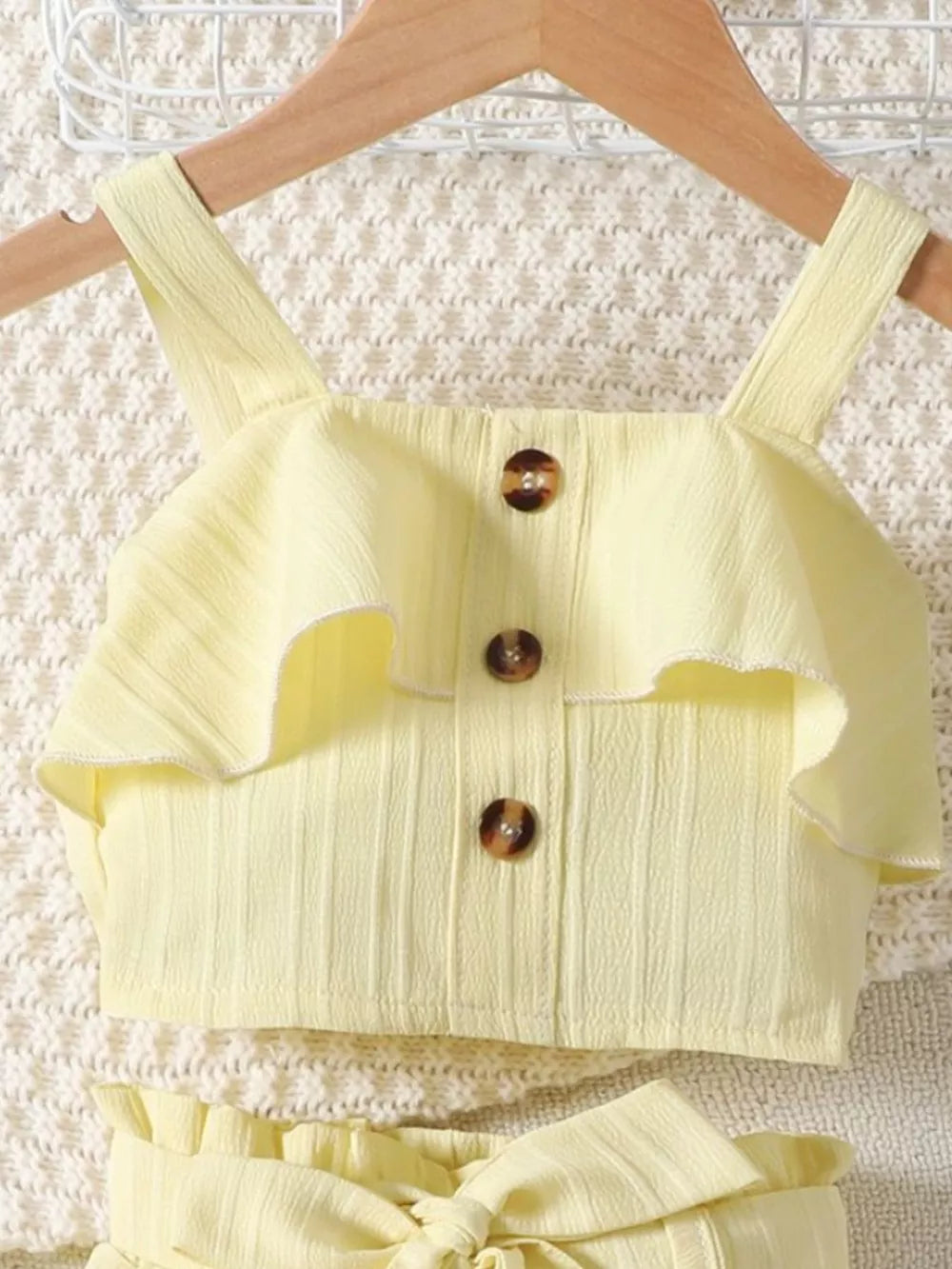 Light yellow ribbed toddler set with ruffled top and button detail.