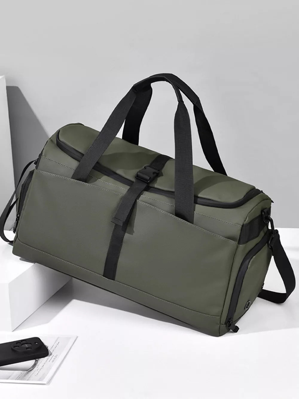 Green Oxford cloth travel bag with black straps and buckle detail.