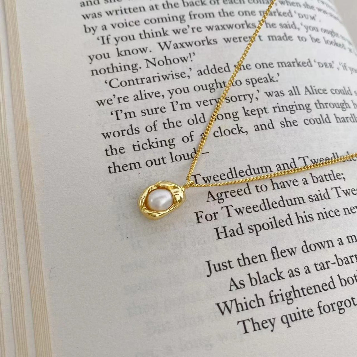 Gold pearl pendant necklace with organic setting on a delicate chain.