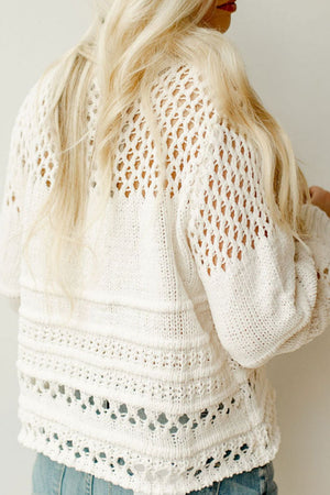 Ivory openwork knit pullover sweater with balloon sleeves and intricate stitch details.