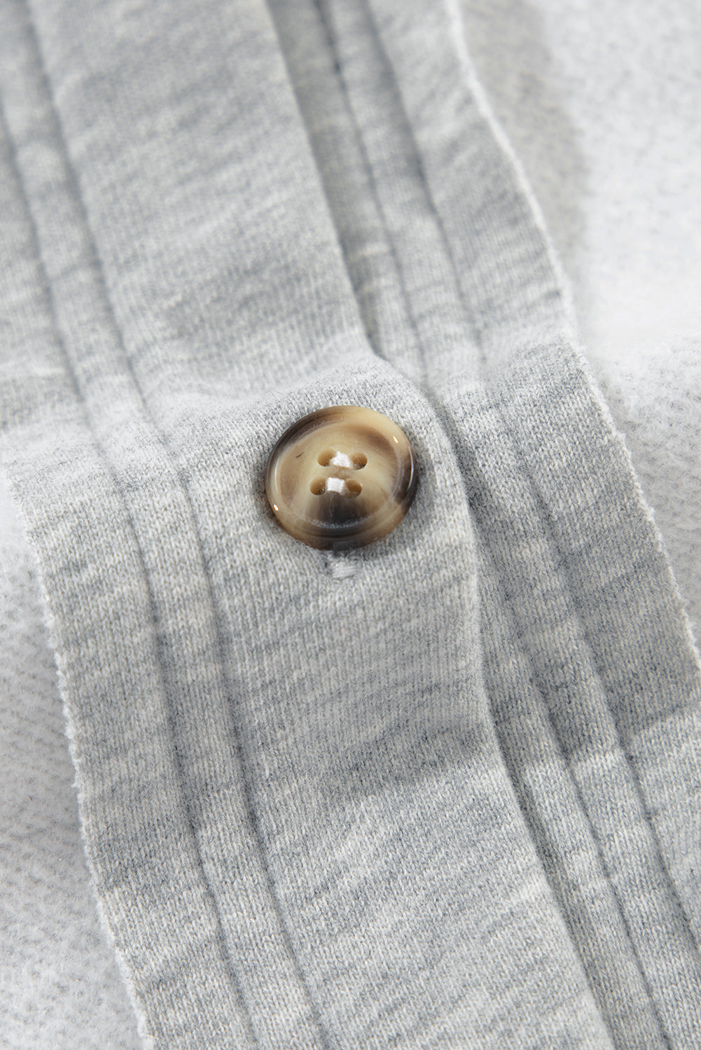 Light gray cotton utility vest with a button closure and contrast trim detail.
