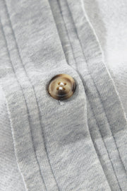 Light gray cotton utility vest with a button closure and contrast trim detail.