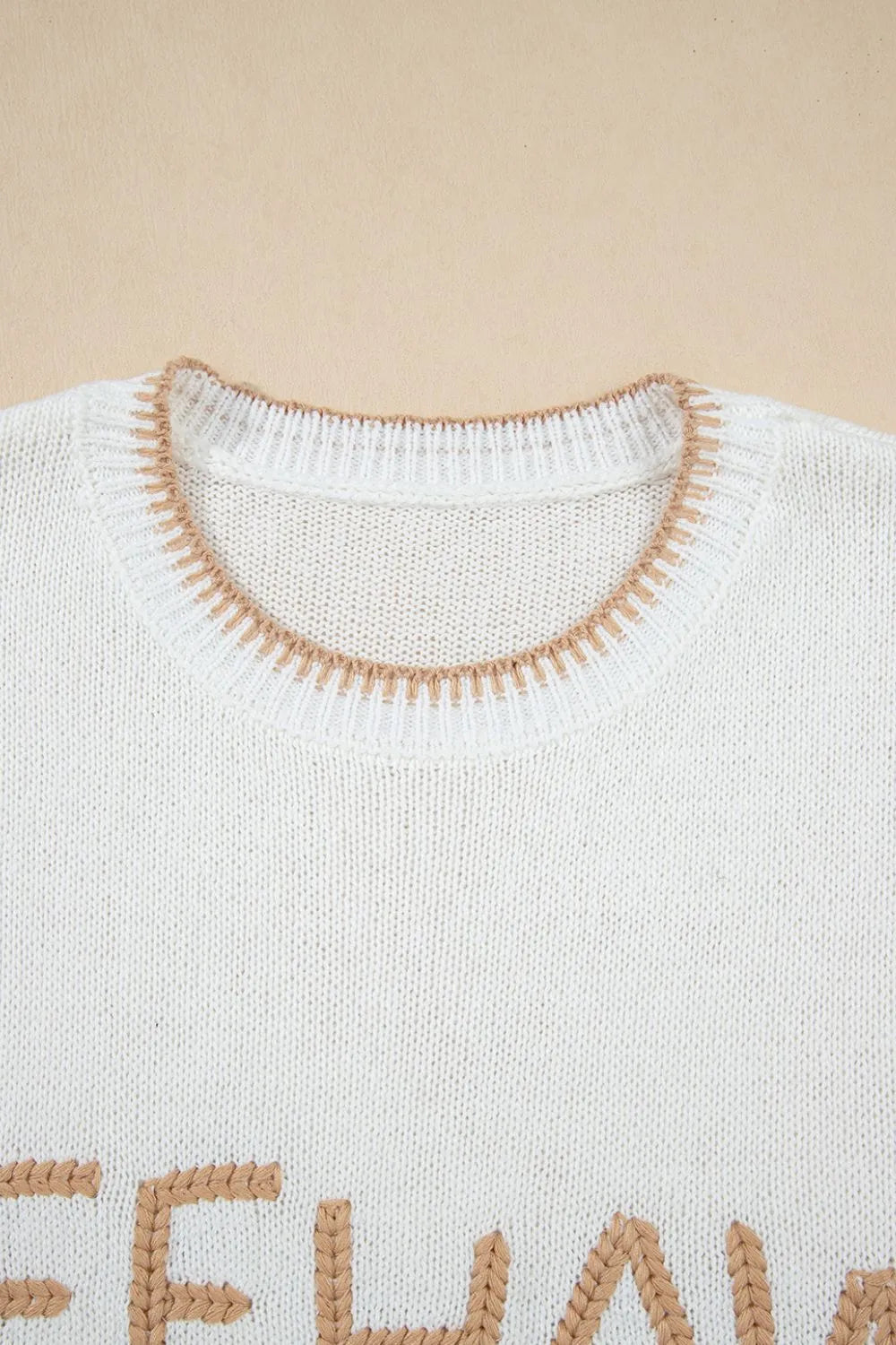 White knit sweater with embroidered "Yeehaw" text and stitch trim neckline