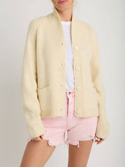 Cream knit buttoned cardigan with pockets and a shawl collar.