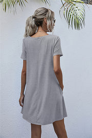 Light gray relaxed pocketed tee dress with short sleeves and crew neck.