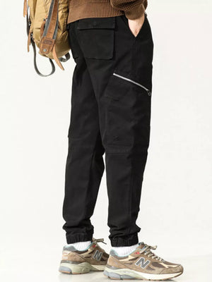 Black cotton cargo pants with zipper pockets and flap pockets.