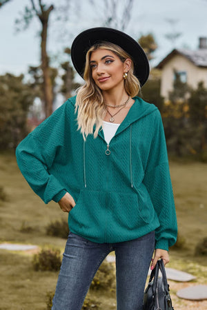 Turquoise textured cable knit zip-up hoodie with drawstring hood and front pocket.
